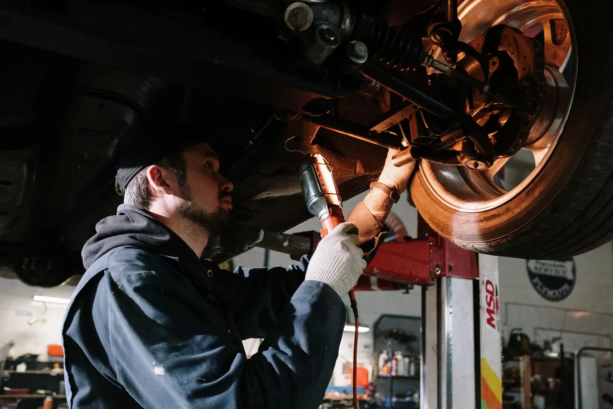 Untersuchung des Unterbodens eines aufgebockten Fahrzeugs